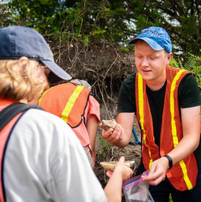 Dr. Ian Winkelstern displays rocks during fieldwork.